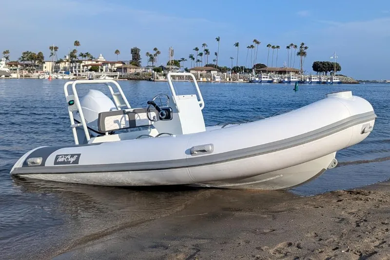 Slide: The Image of Manufacturer Provided Image: 2025 Tide Craft Catalina 13 boat on sandy shore with marina background. - 4