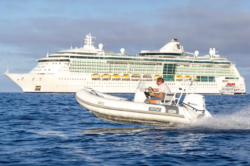 Slide: The Image of Manufacturer Provided Image: Man driving 2025 Tide Craft Catalina 13 boat near large cruise ship on open water. - 8