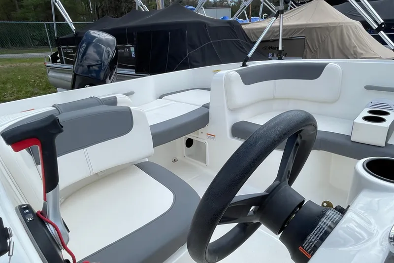 Slide: The Image of 2019 Bayliner Element E16 boat interior with steering wheel and seating area. - 19