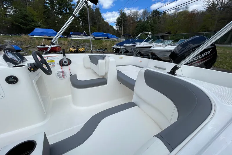Slide: The Image of 2019 Bayliner Element E16 boat interior with gray and white seating, steering wheel, and Mercury engine. - 21