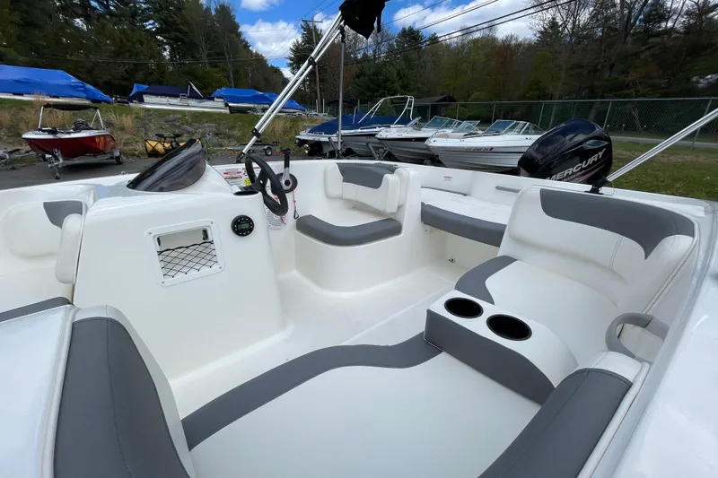 Slide: The Image of 2019 Bayliner Element E16 boat interior with seating and steering wheel, parked outdoors. - 22