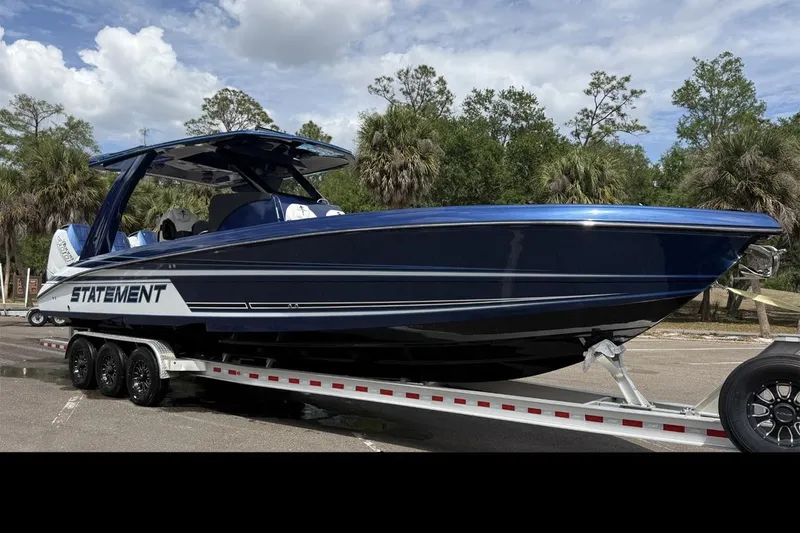The Image of 2027 Statement 350 Open boat on trailer, parked outdoors under cloudy sky. - 0