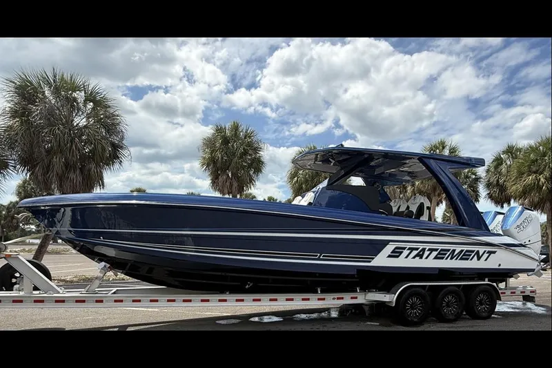 Slide: The Image of 2027 Statement 350 Open boat on trailer, palm trees, cloudy sky background. - 2