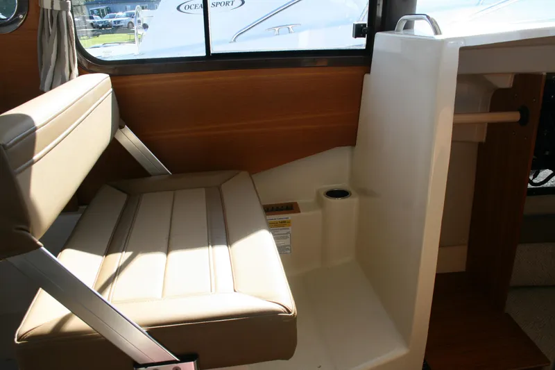 Slide: The Image of 2024 Ranger Tugs R-25 interior seating with beige upholstery and wooden accents. - 15