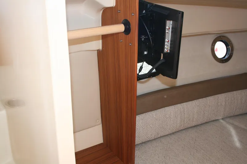 Slide: The Image of 2024 Ranger Tugs R-25 interior with wood accents and mounted TV. - 18