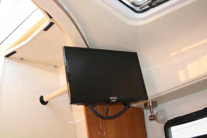 Slide: The Image of 2024 Ranger Tugs R-25 interior with mounted flat-screen TV. - 19