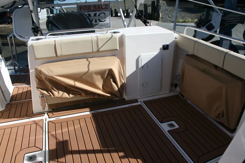 Slide: The Image of 2024 Ranger Tugs R-25 boat deck with cushioned seating and wood-style flooring. - 23