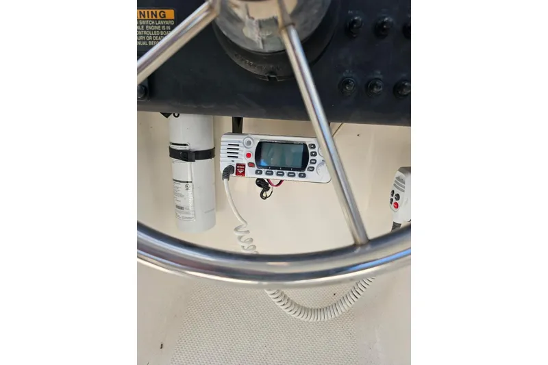 Slide: The Image of 1999 Bayliner 1802 Trophy boat dashboard with steering wheel and marine radio. - 11