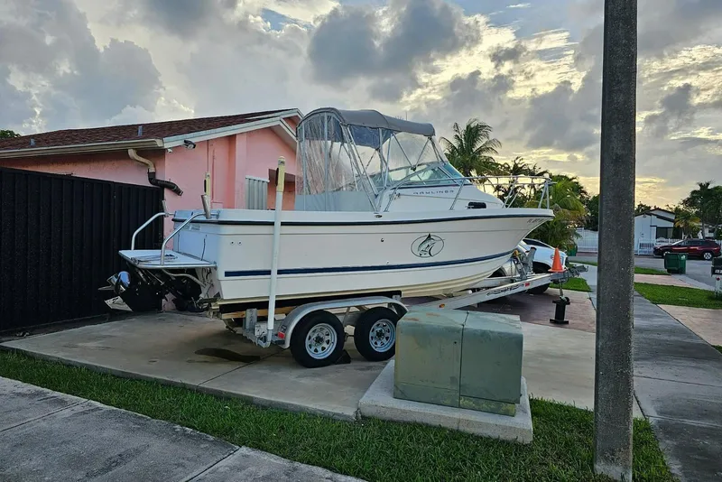 Slide: The Image of 1999 Bayliner 1802 Trophy boat on trailer, parked in residential driveway at sunset. - 4