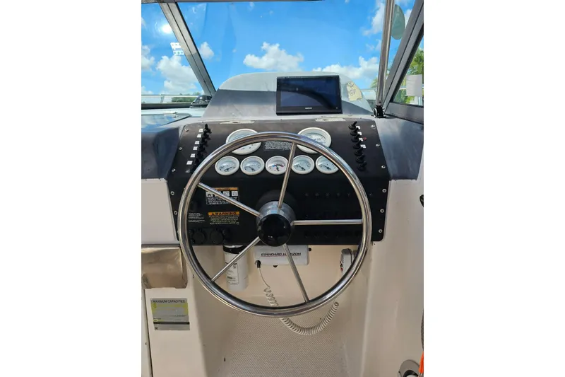 Slide: The Image of 1999 Bayliner 1802 Trophy boat dashboard with steering wheel and gauges. - 7