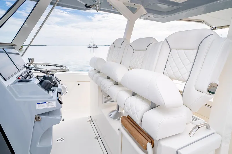 Slide: The Image of Manufacturer Provided Image: 2021 Pursuit S 378 Sport boat interior with white leather seats and steering console. - 10