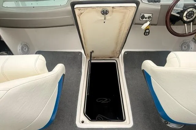 Slide: The Image of 2007 Regal 2200 Bowrider interior with open storage compartment between seats. - 26