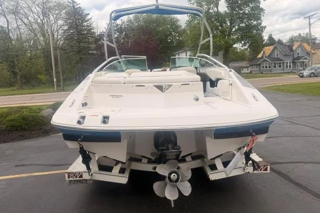 Slide: The Image of 2007 Regal 2200 Bowrider boat, rear view, parked on a trailer in a suburban area. - 3