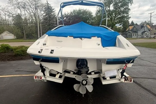 Slide: The Image of 2007 Regal 2200 Bowrider boat with blue cover, parked on a driveway. - 32
