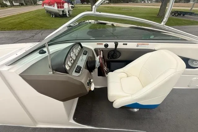 Slide: The Image of 2007 Regal 2200 Bowrider boat interior with steering wheel and white captain's chair. - 5