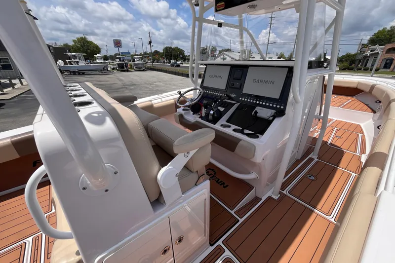 Slide: The Image of 2019 Fountain 38 Center Console boat with Garmin navigation, teak flooring, and beige seating. - 10
