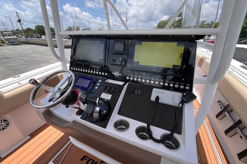 Slide: The Image of 2019 Fountain 38 Center Console boat dashboard with steering wheel and navigation screens. - 11