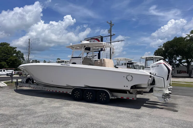 Slide: The Image of 2019 Fountain 38 Center Console boat on trailer under blue sky. - 2