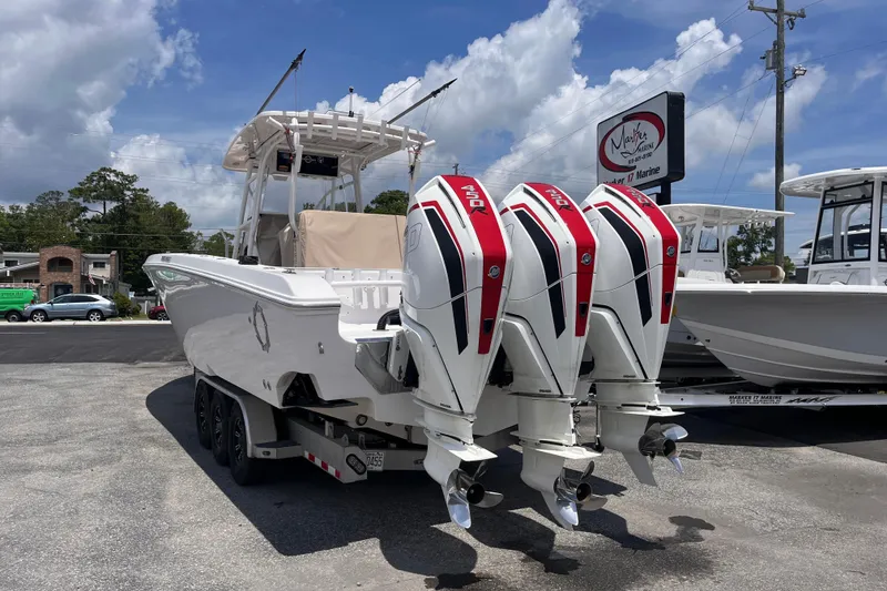 Slide: The Image of 2019 Fountain 38 Center Console boat with triple outboard engines at a marina. - 3