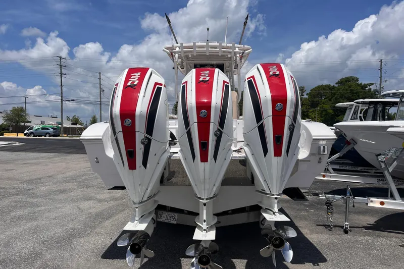 Slide: The Image of 2019 Fountain 38 Center Console with triple 450R outboard engines, parked outdoors. - 4
