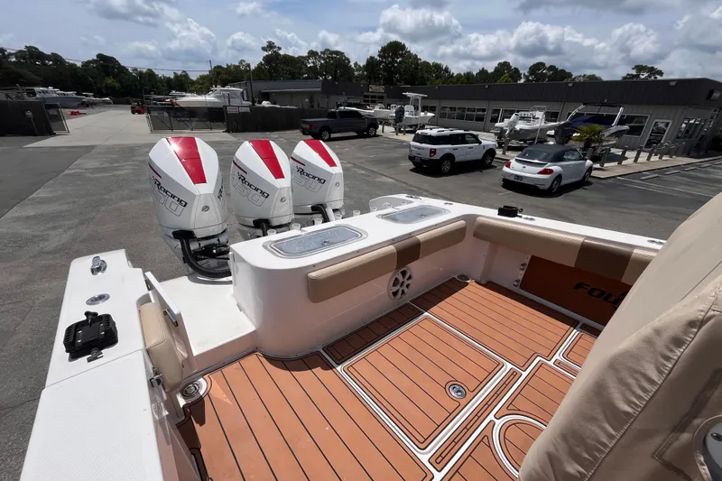 Slide: The Image of 2019 Fountain 38 Center Console boat with triple outboard engines in a marina setting. - 7