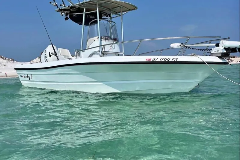 Slide: The Image of 2002 Triumph 210 CC boat on clear turquoise water near sandy beach. - 5