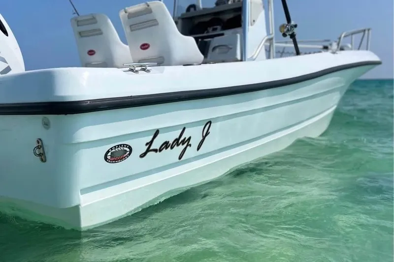 Slide: The Image of 2002 Triumph 210 CC boat named "Lady J" on clear turquoise water. - 6