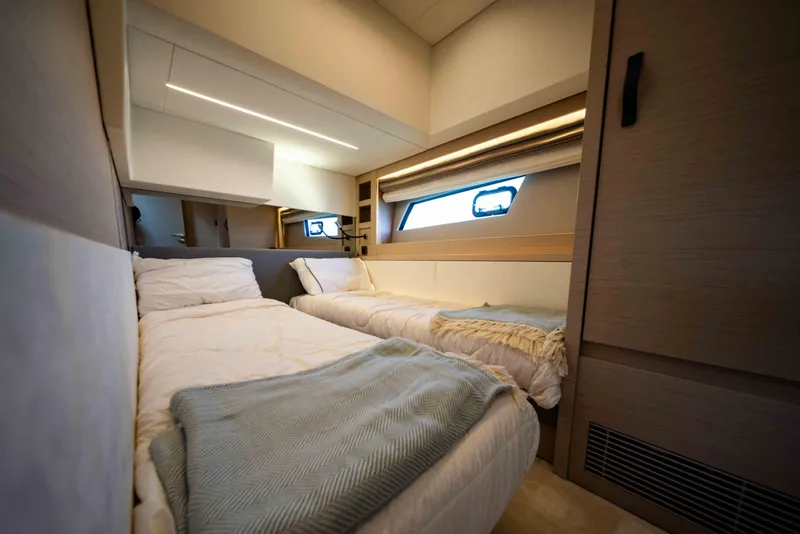 Slide: The Image of Luxurious twin cabin interior of 2023 Prestige 520S yacht, featuring modern design and cozy bedding. - 10