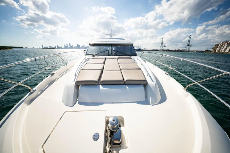 Slide: The Image of Luxury 2023 Prestige 520S yacht cruising with city skyline in background. - 13