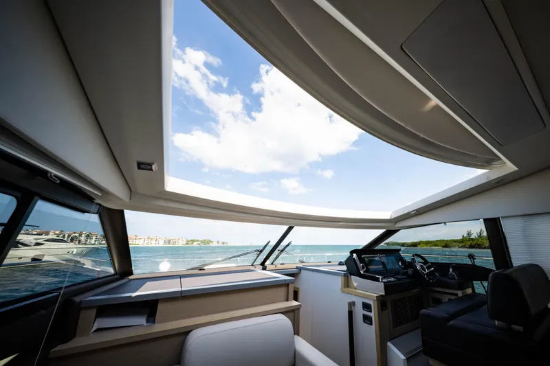 Slide: The Image of Interior view of 2023 Prestige 520S yacht with panoramic sunroof and ocean backdrop. - 5