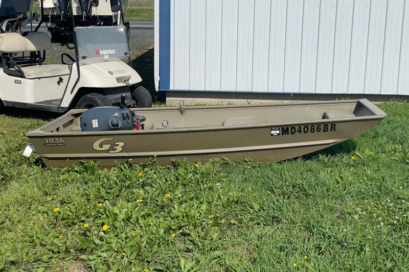 The Image of 2020 G3 Gator Tough 1036 boat on grass beside a golf cart. - 1