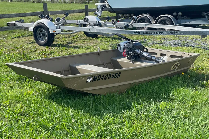 Slide: The Image of 2020 G3 Gator Tough 1036 boat on grass beside trailer. - 3