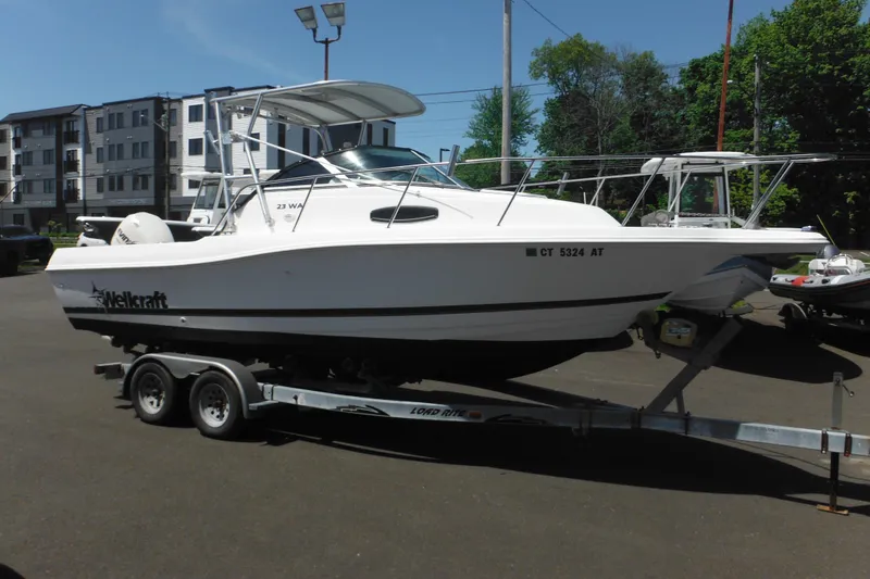 The Image of 1998 Wellcraft 23 Excel boat on trailer, parked outdoors in a lot. - 1