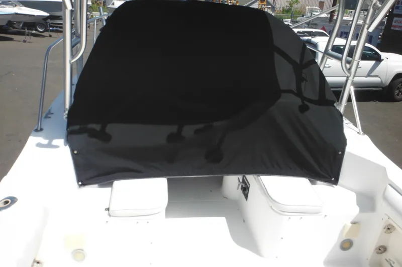 Slide: The Image of 1998 Wellcraft 23 Excel boat with black cover, docked outdoors. - 12
