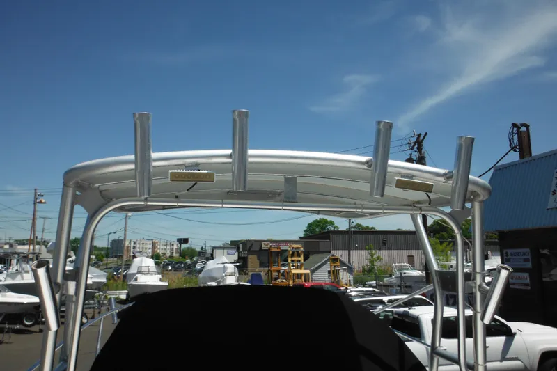 Slide: The Image of 1998 Wellcraft 23 Excel boat with rod holders, viewed from the rear under a clear blue sky. - 13