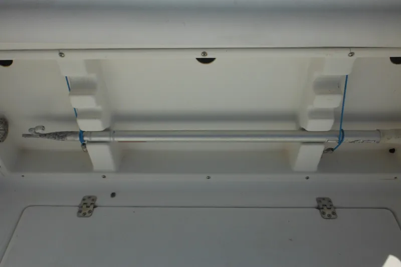 Slide: The Image of Storage compartment in a 1998 Wellcraft 23 Excel boat, featuring a secured rod holder. - 20