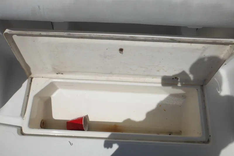 Slide: The Image of Open storage compartment on 1998 Wellcraft 23 Excel boat with a red cup inside. - 22