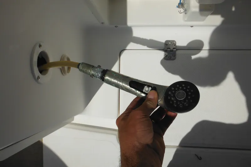 Slide: The Image of Hand holding a showerhead on a 1998 Wellcraft 23 Excel boat. - 23