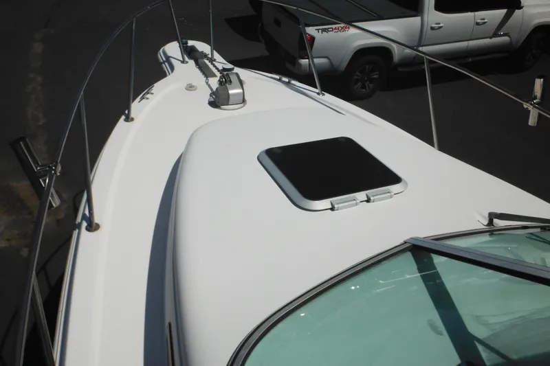 Slide: The Image of 1998 Wellcraft 23 Excel boat deck with hatch and railing, parked near a truck. - 24
