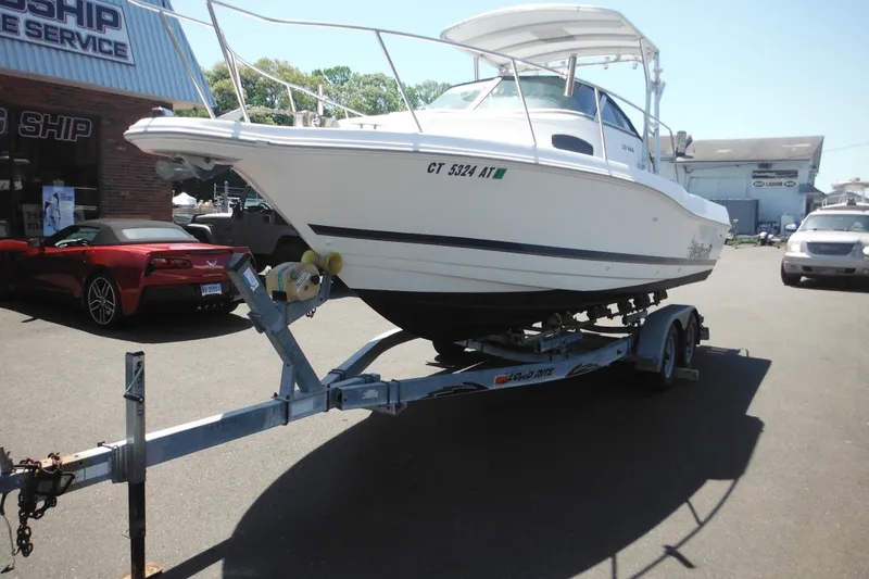 Slide: The Image of 1998 Wellcraft 23 Excel boat on trailer at dealership, sunny day. - 3