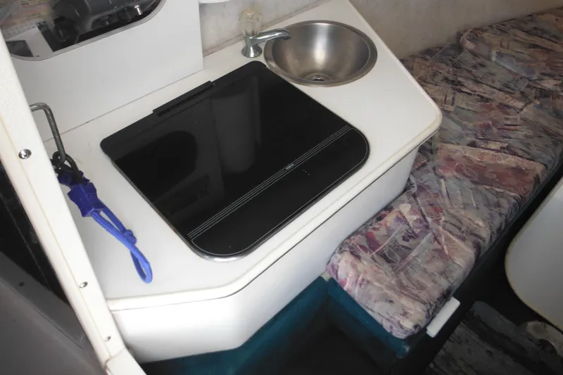 Slide: The Image of 1998 Wellcraft 23 Excel boat interior with sink, stove, and patterned seating. - 36