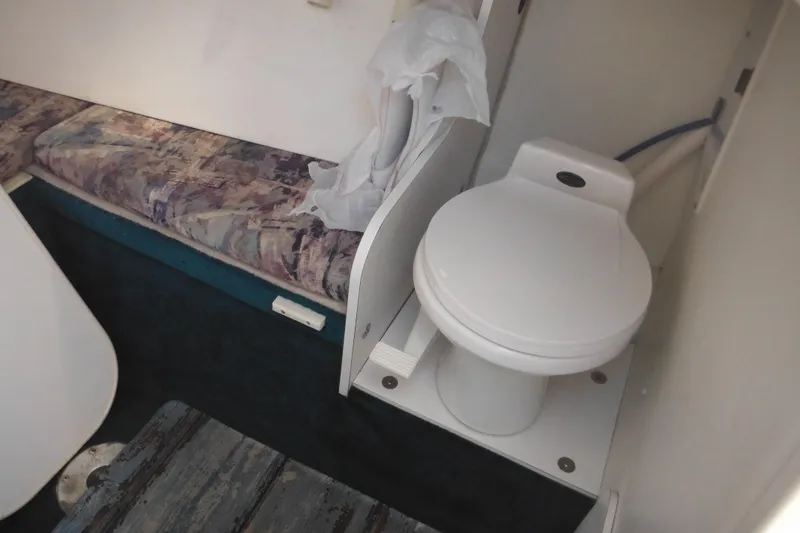 Slide: The Image of Interior of 1998 Wellcraft 23 Excel boat showing compact toilet and seating area. - 37