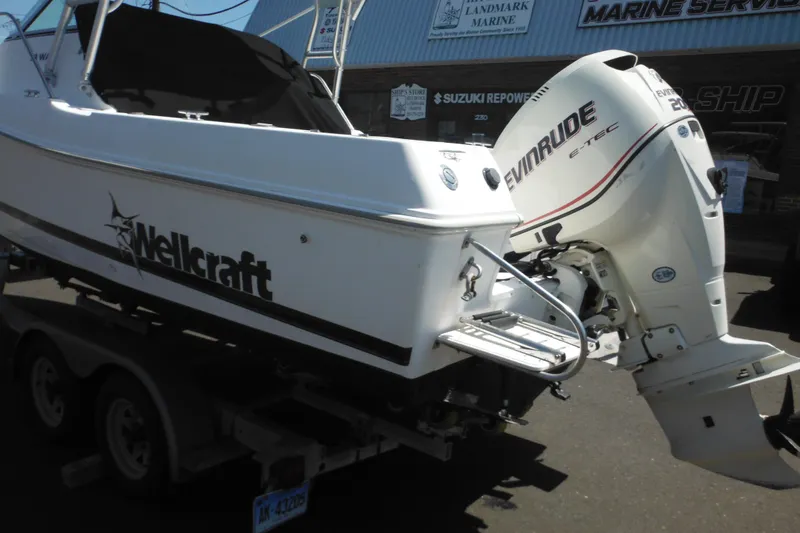 Slide: The Image of 1998 Wellcraft 23 Excel boat with Evinrude engine on trailer at marine service shop. - 5