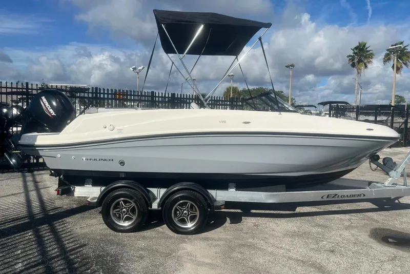 The Image of 2023 Bayliner VR5 Bowrider OB on trailer, parked outdoors under cloudy sky. - 1