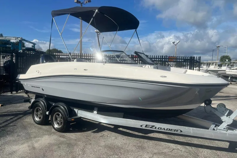 Slide: The Image of 2023 Bayliner VR5 Bowrider OB on trailer, parked outdoors under a blue sky. - 5