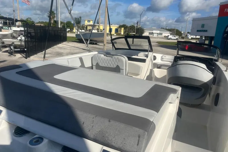 Slide: The Image of 2023 Bayliner VR5 Bowrider OB interior with seating and dashboard, parked outdoors. - 8