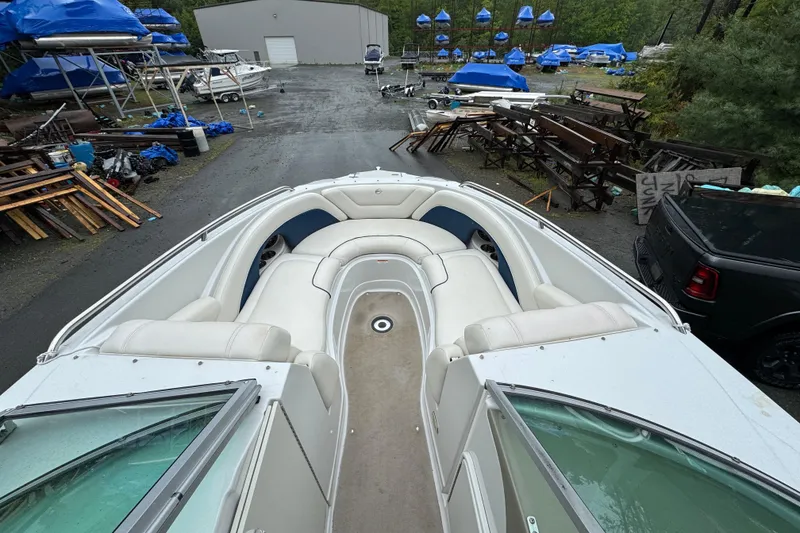 Slide: The Image of 2009 Crownline 240 LS boat with white seating in a storage yard. - 10