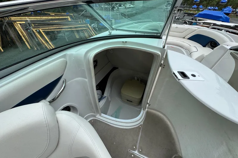 Slide: The Image of 2009 Crownline 240 LS boat interior with open compartment and seating area. - 11