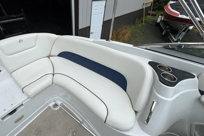 Slide: The Image of 2009 Crownline 240 LS boat interior with white seating and cup holders. - 6