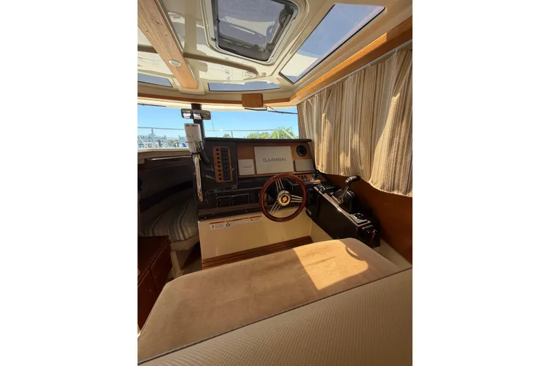 Slide: The Image of Interior of 2021 Ranger Tugs R-27 boat with helm, steering wheel, and navigation equipment. - 11